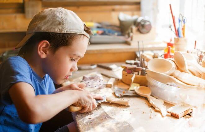 A child carves in wood
