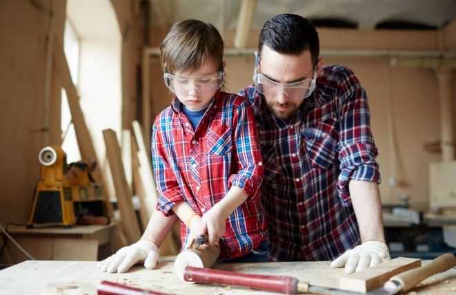 Father and son carve wood